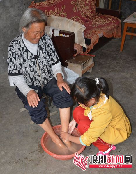 图为 上二年级8岁的小学生在给家住农村的奶奶洗脚